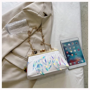 Detail of white evening bag with holographic sequins, lace trim, and pearl clasp closure