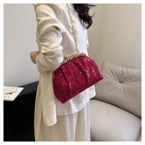 Detail of rose red sequin evening bag with gold metal frame and ornate clasp