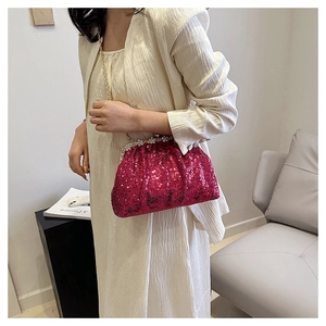 Detail of rose red sequin evening bag with gold chain strap and sparkling diamond clasp