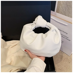 Detailed view of the white knotted handle and soft pleated texture on this cloud bag
