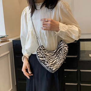 Sac demi-lune zébré chic avec chaîne décorative et fine bandoulière en métal