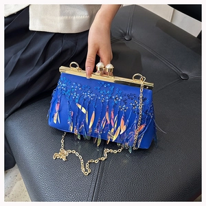 Detail of royal blue evening clutch with shimmering sequins and flowing fringe tassels