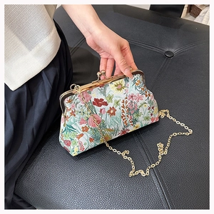 Detailed view of vintage floral brocade clutch with golden clasp and chain strap