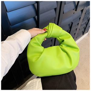 Macro detail of high-quality neon green knotted handle bag with soft leather texture