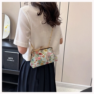 Close-up of vintage floral jacquard fabric bag with gold chain strap and metal clasp