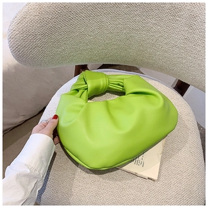 Detail of the neon green knotted handle and pleated texture of the fashion cloud handbag