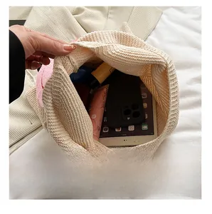 Κοντινό πλάνο εσωτερικού ψάθινης τσάντας με χώρο για τάμπλετ και διάφορα καλλυντικά
