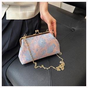 Detailed macro of vintage floral jacquard fabric and gold metal kiss-lock frame
