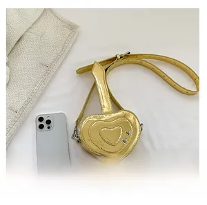 Confronto dettagliato delle dimensioni tra borsa a tracolla a cuore oro e smartphone