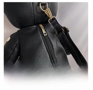 Detail view of smooth golden zipper and leather texture on a bear-shaped backpack