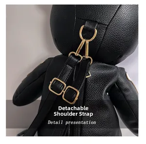 Macro detail of detachable gold-tone metal hooks and adjustable straps on black leather bag