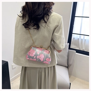 Close-up of vintage floral embroidery and golden metal frame on an elegant clutch bag