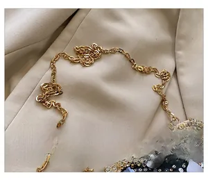 Détail de la bandoulière en chaîne dorée et paillettes noires sur un sac à bandoulière chic