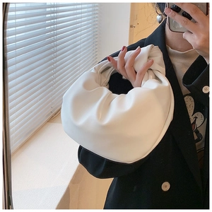 Mirror selfie showing the white knotted cloud bag with trendy pleated faux leather finish