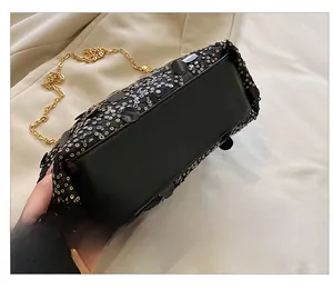 Détail de la base en cuir noir et de la chaîne métallique du sac à paillettes