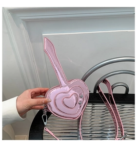 Dettaglio della borsa a cuore rosa in pelle verniciata con motivi a rilievo