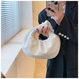 Detail of white knotted dumpling bag showing soft leather pleats and texture