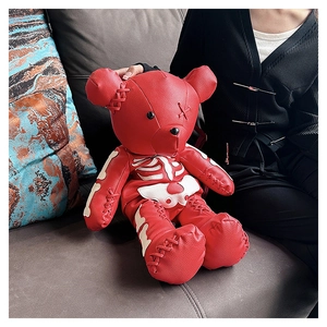 Red teddy bear backpack with white bone stitching in a dark goth aesthetic style