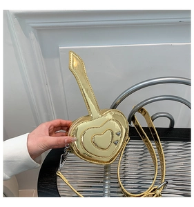 Vista dettagliata della mini borsa a cuore con finitura metallica dorata e impunture