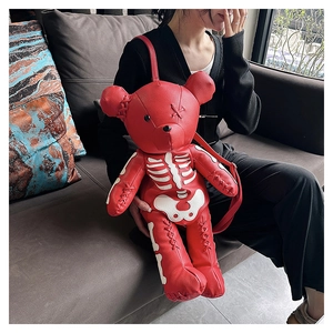 Detailed close-up of a red gothic bear backpack with white skeleton print and hand-stitched details