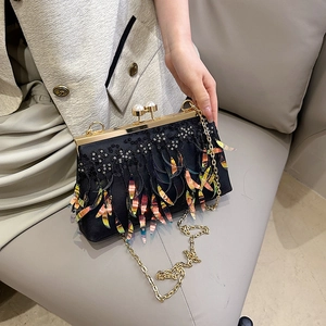 Elegant black evening bag with iridescent leaf tassels and golden pearl clasp