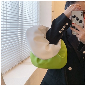 Detail of stylish knotted ruched cloud bag in white and green color block design