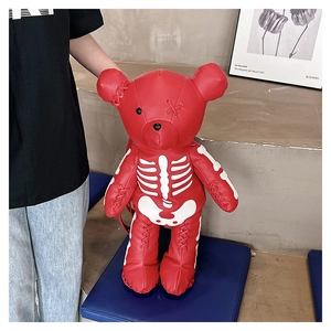Close-up of red bear-shaped gothic backpack showing white skeleton print and stitched details