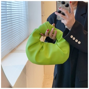 Detail of neon green knotted hobo bag with pleated texture and soft leather finish
