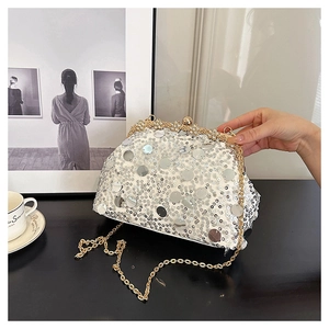 Détails de paillettes blanches et fermoir floral doré sur une pochette de soirée chic