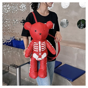 Detail of red bear backpack featuring gothic bone print and punk style cross-stitched eyes