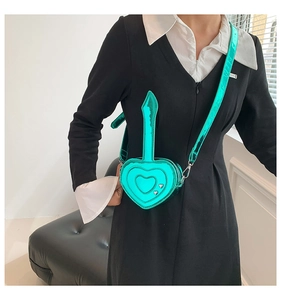 Mini borsa a tracolla a forma di cuore verde metallizzato con borchie d'argento su modella