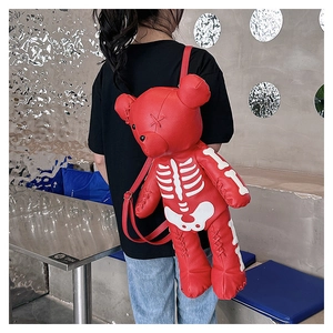 Macro shot of red leather teddy bear backpack with skeleton print and cross stitch details