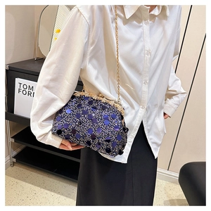 Détail de la pochette de soirée à paillettes bleu marine avec cadre doré et chaîne