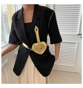 Dettaglio di una mini borsa a vita dorata a forma di cuore in pelle verniciata elegante