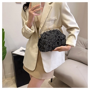 Détail d'un sac de soirée noir à paillettes avec cadre en strass et chaîne dorée vintage