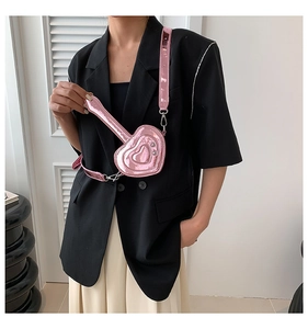 Vista dettagliata della mini borsa a cuore rosa metallizzato indossata come tracolla