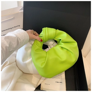 Detail of lime green knotted leather handbag with soft pleats in a luxury gift box