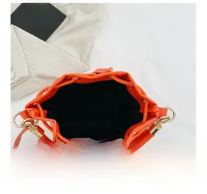 Deep interior view of orange leather bucket bag with black lining and gold hardware