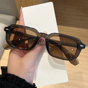 Detail showing vintage rectangular brown frames with metallic studs and tinted lenses