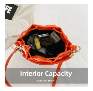Detailed interior view of a bright orange drawstring bucket bag showing large capacity