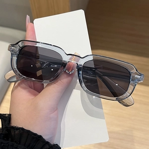 Detail shot of matte dark grey rectangular sunglasses with visible metal hinge quality