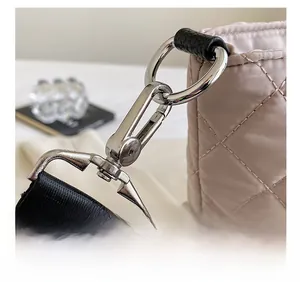 Detailed macro view of silver metal hook and quilted fabric on large tote bag