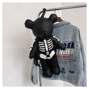 Detail of gothic black leather teddy bear backpack featuring white skeleton print design