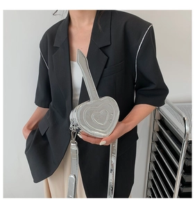 Dettaglio mini borsa cuore argento metallizzato con manico a spada e tracolla regolabile