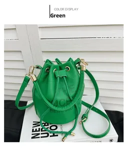 Detail of green drawstring bucket bag with litchi grain texture and metal ring handle