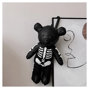Close-up of black teddy bear backpack with white skeletal bone print and stitch detail