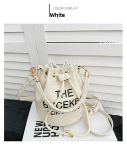 Detail of white bucket bag featuring pebble leather texture and black letter printing