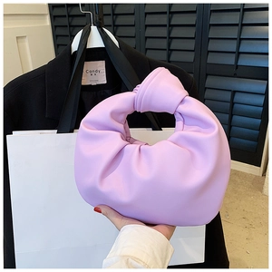 Detail of light purple knotted handle handbag with cloud pleats held by a person