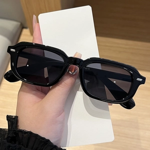Close-up of black square sunglasses with metal rivets and model number 5618 detail