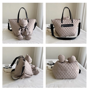 Khaki quilted large tote bag with crossbody strap and stylized frog plush pendant